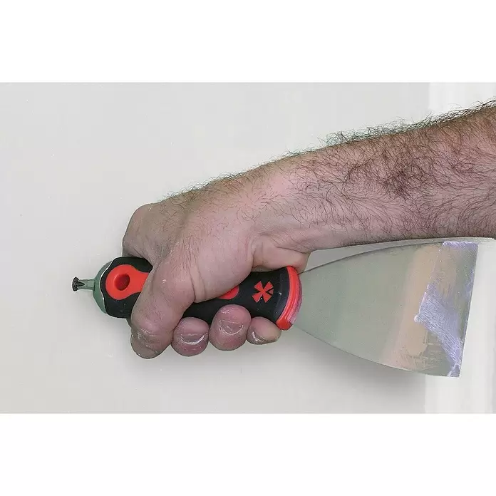 Mondelin Spachtel - Geeignet für: Spachtelmasse, Schwarz - Hand verwendet schwarz-roten Spachtel mit Sternsymbol-Griff und Metallklinge an einer Wand.