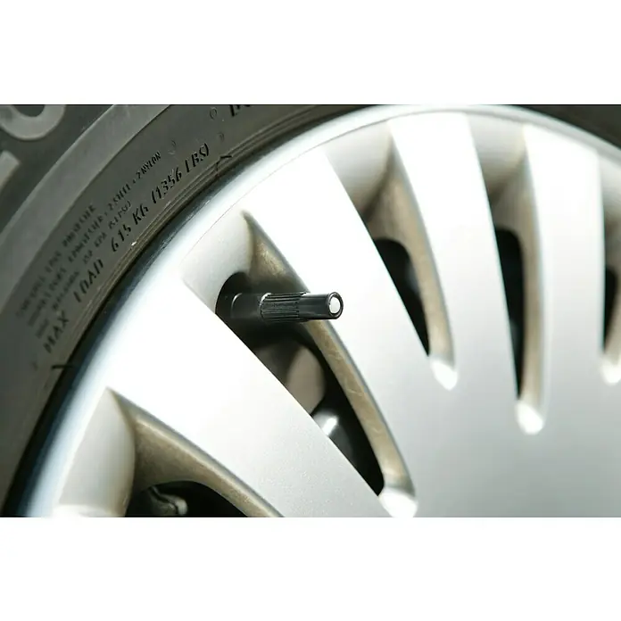 UniTEC Ventilverlängerung - 4 Stk., Geeignet für: Autoventile - Nahaufnahme eines Reifens mit Felge und einem schwarzen Reifenventil mit Ventilkappe.