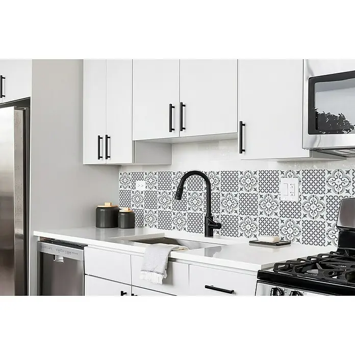 D-c-fix Fliesensticker Wall Tiles Jamila - 6 Stk., 15 x 15 cm, Grau - Elegante Küche mit weißen Schränken und einer stilvollen Mosaik-Rückwand, die dem Raum einen modernen Touch verleiht. Die schwarzen Griffe setzen dabei einen edlen Akzent.