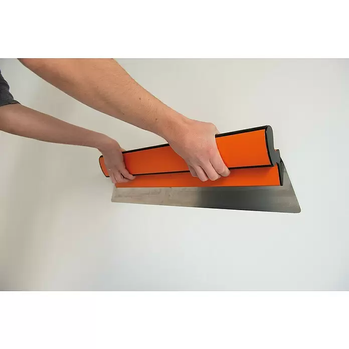 Mondelin Feinspachtel Ergolame - Stärke: 0,3 mm - Hände halten eine orange-schwarze Glättekelle zum Glätten von Oberflächen.