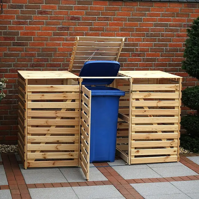 Promadino Mülltonnenbox Variov -  - Eine hölzerne Mülltonnenbox mit blauer Mülltonne vor einer Backsteinmauer, die eine stilvolle Aufbewahrung für Abfallbehälter bietet.