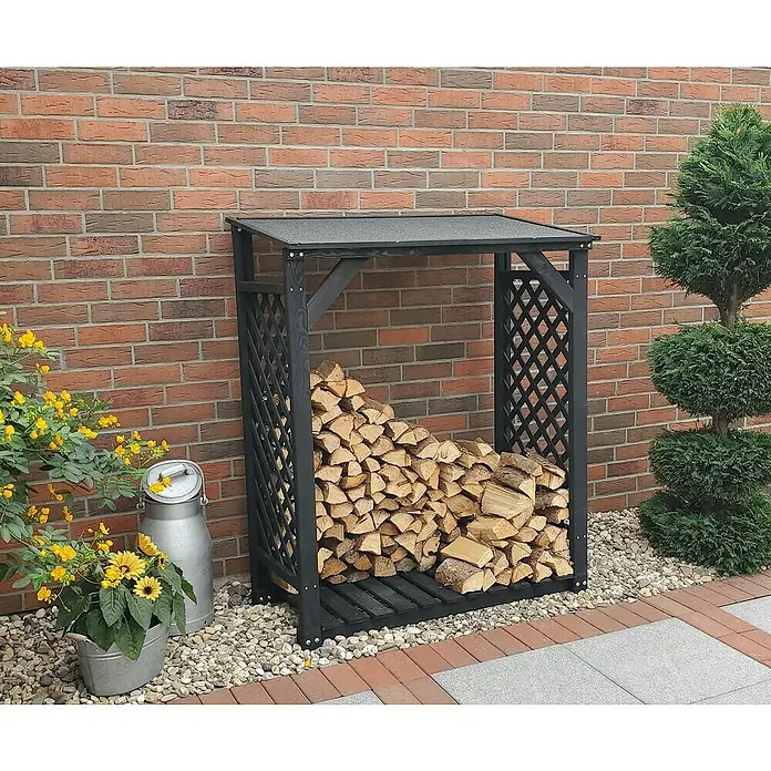 Promadino Kaminholzregal Speyer - 120 x 68 x 148 cm, Holz, Anthrazit - Überdachter Kaminholzunterstand aus Holz, gefüllt mit Holzscheiten, vor einer Ziegelwand.