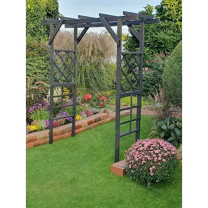 Promadino Pergola Ben - 60 x 200 x 210 cm, Anthrazit, Holz - Garten-Szene mit einer dunklen Holzlaube, umgeben von Blumen und Grünpflanzen, die eine friedliche und natürliche Atmosphäre schaffen.