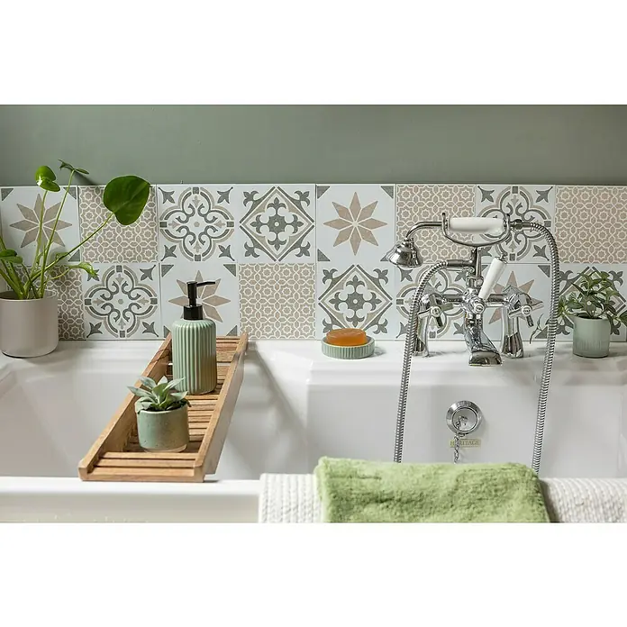 D-c-fix Fliesensticker Wall Tiles Jamila - 6 Stk., 15 x 15 cm, Olive - Eine helle Badewanne mit Armaturen und einer hölzernen Ablage mit Seifenspender und Pflanzen, vor dekorativen Fliesen und einer grünen Wand.
