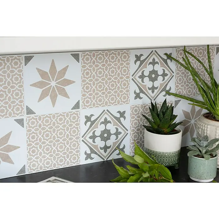D-c-fix Fliesensticker Wall Tiles Nadia - 6 Stk., 15 x 15 cm, Olive - Nahaufnahme von dekorativen Fliesen in Beige-, Grau- und Weißtönen, die eine stilvolle Küchenrückwand bilden und durch Pflanzen ergänzt werden.