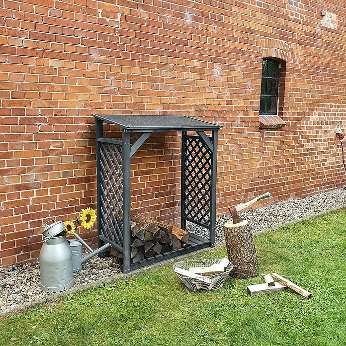 Promadino Kaminholzregal Speyer - 120 x 68 x 148 cm, Holz, Anthrazit - Brennholzregal aus grauem Metall mit Gitterdesign, das vor einer roten Backsteinmauer aufgestellt ist und Holzscheite beherbergt.