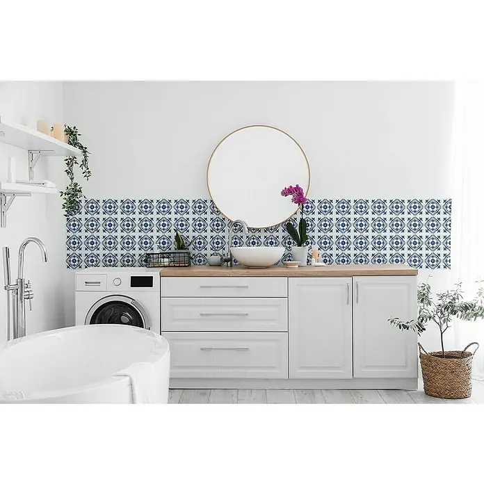 D-c-fix Fliesensticker Wall Tiles Nadia - 6 Stk., 15 x 15 cm, Blau - Badezimmer mit Waschmaschine, runder Spiegel über einem Waschbecken auf einer Holzplatte und weißen Schränken mit blauen Fliesen als Spritzschutz.