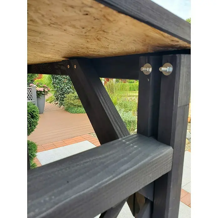 Promadino Kaminholzregal Speyer - 120 x 68 x 148 cm, Holz, Anthrazit - Nahaufnahme eines robusten, schwarz gebeizten Holztisches, der Stabilität und handwerkliches Können durch seine Konstruktion und Details zeigt.