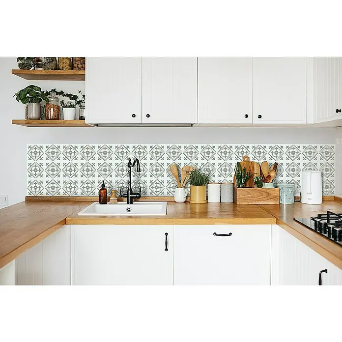 D-c-fix Fliesensticker Wall Tiles Nadia - 6 Stk., 15 x 15 cm, Olive - Helle Küche mit weißen Schränken und einer Arbeitsplatte aus Holz mit gemusterten Fliesen als Spritzschutz.