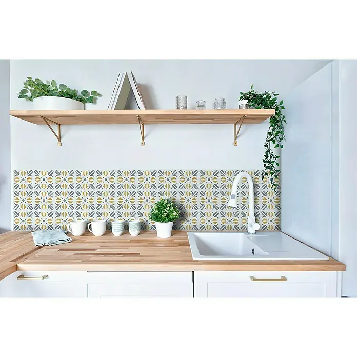 D-c-fix Fliesensticker Wall Tiles Cubia - 6 Stk., 15 x 15 cm, Gold - Nahaufnahme einer Küche mit einer stilvollen Arbeitsplatte, gemusterten Wandfliesen und dekorativen Elementen wie Pflanzen und Geschirr.