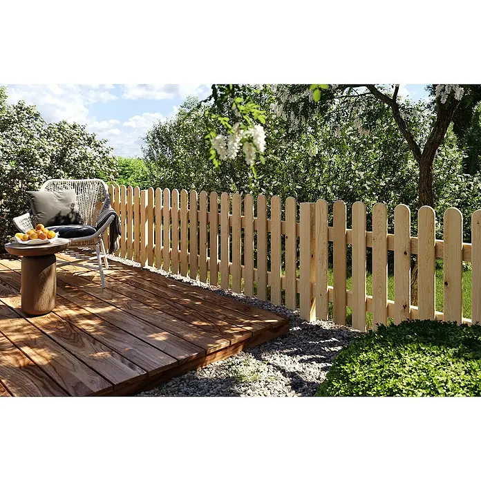 Joda Vorgartenzaun Lübeck - 180 x 80 cm, Holz - Gartenszene mit einem Holzzaun, der einen kleinen Gartenbereich umgibt. Auf der Holzterrasse stehen ein Stuhl und ein Tisch mit Obst.