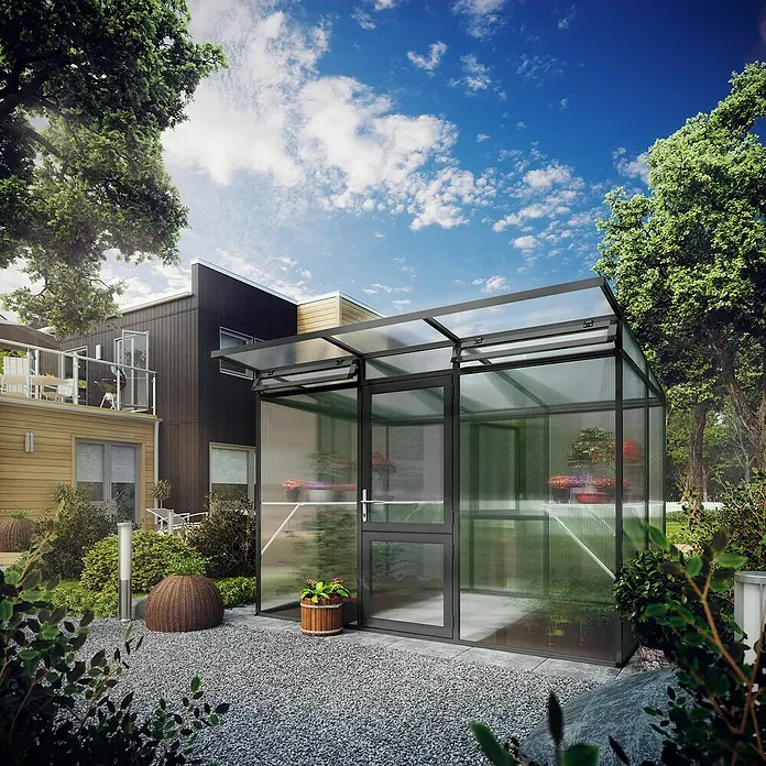 KGT Gewächshaus Linea II - Außenmaß inkl. Dachüberstand (B x T): 297 x 204 cm, 10 mm, Anthrazitgrau - Ein modernes Gewächshaus mit transparenten Wänden und einem grauen Rahmen, eingebettet in eine grüne Gartenlandschaft neben einem Wohnhaus.