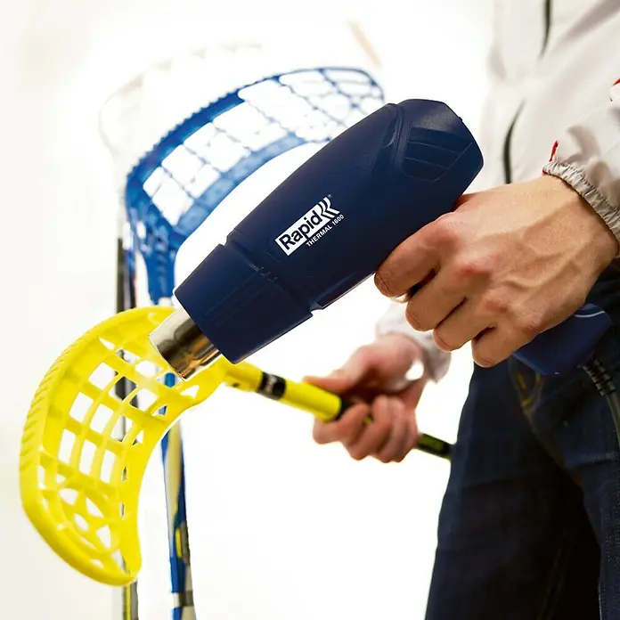 Rapid Pistola de aire caliente Thermal 1600 - 1.600 W, Rango de temperaturas: 400 °C - 550 °C - Un hombre da forma a un stick de floorball con una pistola de calor Rapid Thermal 1600. La herramienta permite calentar y dar forma con precisión.
