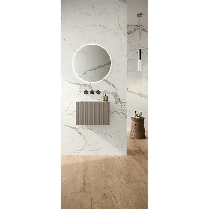 Corso Italia Feinsteinzeugfliese Marble Calacatta - 120 x 278 cm, Weiß, Glänzend - Badezimmer mit modernem Waschtisch, rundem Spiegel mit Beleuchtung, Holzhocker und Pendelleuchte vor Marmorwand und Holzboden.