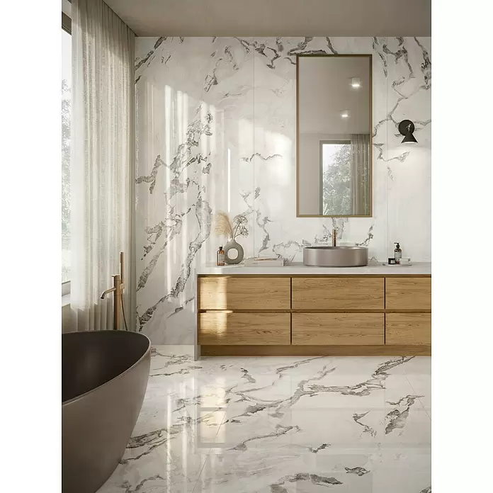 Corso Italia Feinsteinzeugfliese Lunar - 120 x 278 cm, Grau, Glänzend - Modernes Badezimmer mit weißen Marmorwänden und -boden, Holzwaschtisch und dunkler Badewanne.