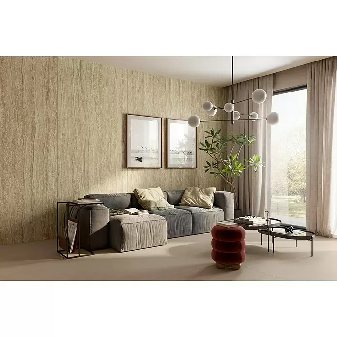 Corso Italia Feinsteinzeugfliese Traventino - 120 x 278 cm, Sand, Matt - Hellbraune, vertikal geäderte Wandpaneele bilden einen eleganten Hintergrund in einem modernen Wohnzimmer.