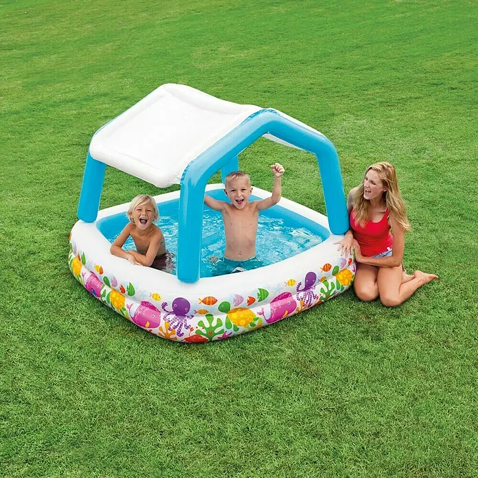Intex Piscina hinchable Sun Shade - 157 x 157 x 122 cm, Capacidad volumétrica: 295 l - Una piscina inflable y colorida con toldo, donde niños están jugando y una mujer está sentada al lado. Perfecto para la diversión de verano en el jardín.