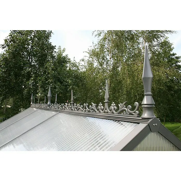 KGT Gewächshaus-Firstkrone - Anthrazitgrau - Nahaufnahme des filigranen Ziergiebels eines Gewächshauses mit spitzen Zierelementen vor grünem Hintergrund.