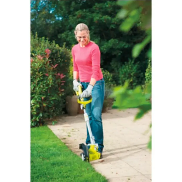 Ryobi Recortabordes eléctrico RLT6030 - 600 W, Ancho de corte hilo: 30 cm - Mujer usando una cizalla de bordes en el jardín.