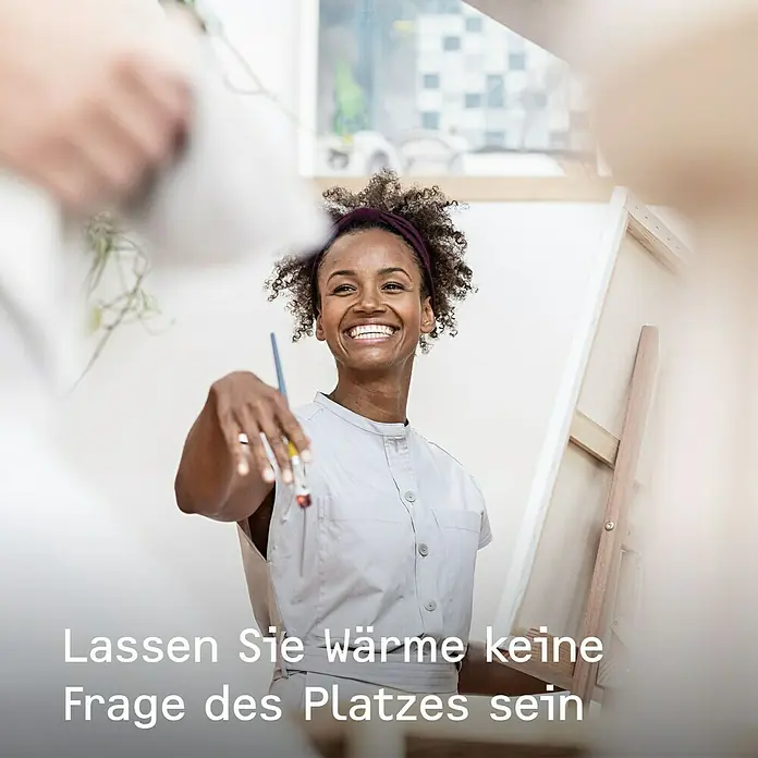 Stiebel Eltron Konvektorheizung - 2.000 W, Raumheizvermögen: 25 m², Weiß - Eine lachende Frau steht vor einer Staffelei und hält einen Pinsel in der Hand.