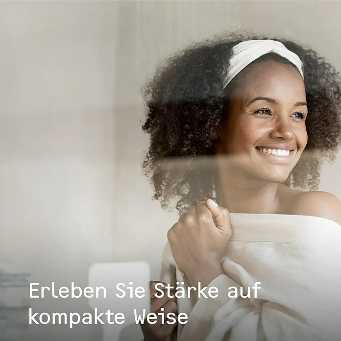 Stiebel Eltron Heizlüfter CK 20 TREND Wandmontage - 2.000 W, Raumheizvermögen: 25 m², Alpinweiß - Frau mit Stirnband und Tuch lächelt entspannt, während sie die kompakte Stärke genießt, die ihr Leben bereichert.