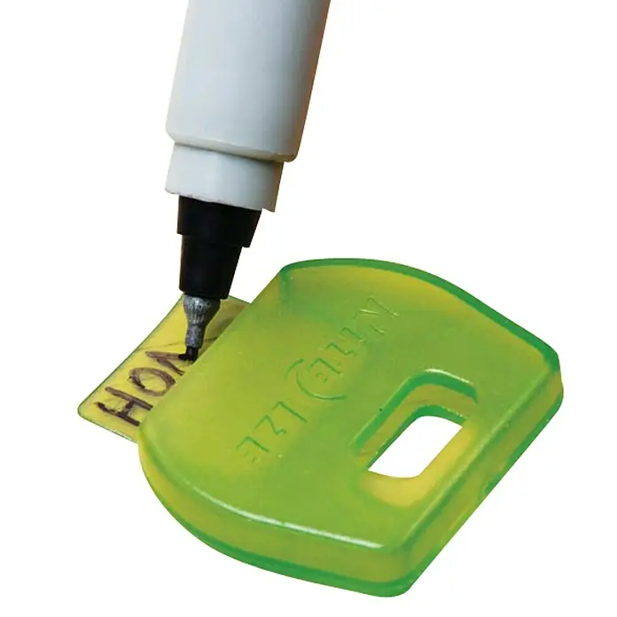 Nite Ize Schlüsselkappe - 4 Stk., Mehrfarbig - Nahaufnahme eines grünen Nite Ize KeyRack Key ID Sleeve, der mit einem Stift auf einem gelben Etikett beschriftet wird.