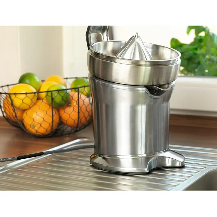 Tesa Cinta aislante Iso Tape - Blanco, L x An: 20 m x 19 mm - Un exprimidor eléctrico de cítricos hecho de acero inoxidable está sobre un fregadero al lado de una cesta de frutas cítricas. Utensilio práctico.
