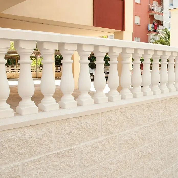 Pasamano Palermo - Hormigón - Primer plano de una balaustrada blanca con elegantes columnas en un patio o balcón. Arquitectura clásica en blanco brillante.