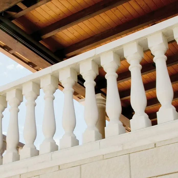 Tapa para balaustrada Roma - 11,5 x 10 x 2 cm, Blanco, Hormigón - Elegante balaustrada blanca con columnas ornamentadas sobre un techo de madera, destacando detalles arquitectónicos y artesanía de calidad.