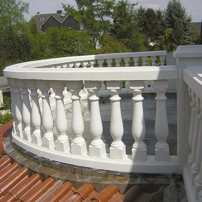 Balaustrada Italia 75 - 12 x 12 x 75 cm, Blanco, Hormigón - Primer plano de una balaustrada blanca sobre un techo con tejas rojas, mostrando detalles arquitectónicos y un estilo clásico.
