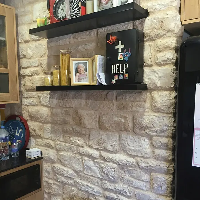 Revestimiento de piedra Silleria Cobre - Cobre, Cantidad total: 4 pzs. - Un botiquín de primeros auxilios con la inscripción "HELP" y pegatinas, colocado en un estante de pared de piedra rústica, rodeado de decoración.