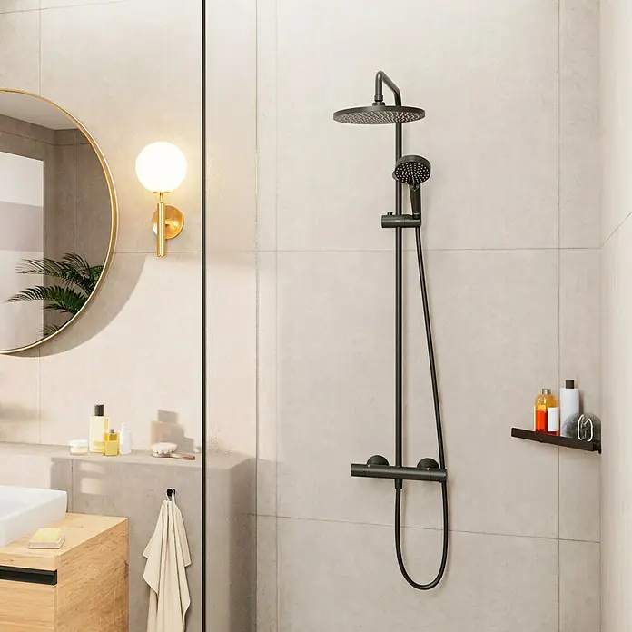 Hansgrohe Vernis Blend Duschsystem 240 - Lochabstand: 15 cm, Schwarz - Eine moderne, mattschwarze Duscharmatur mit Kopf- und Handbrause vor hellen Fliesen. Ein stilvolles Badezimmer-Design.