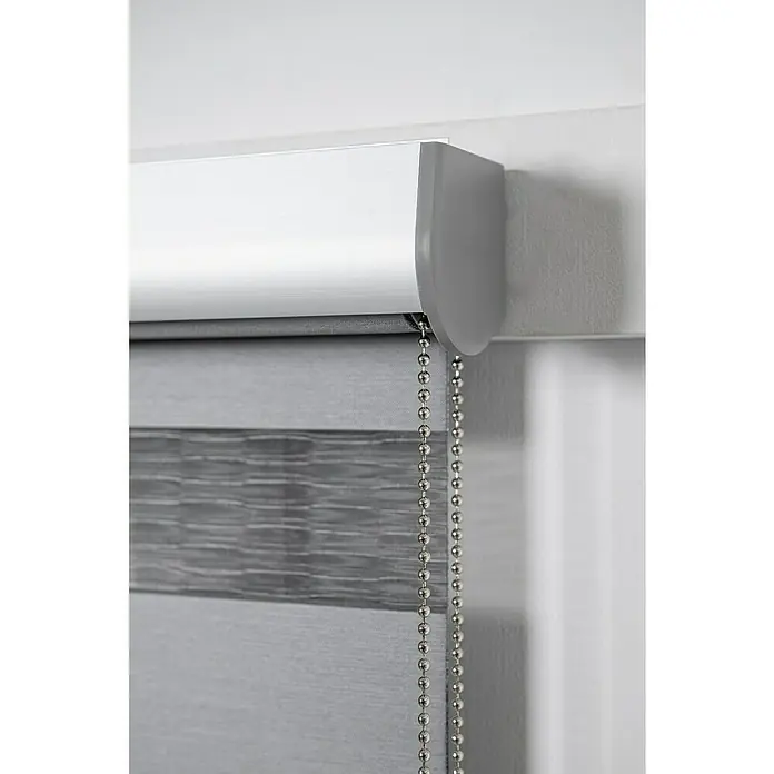 Estor noche y día Premium - An x Al: 200 x 250 cm, Gris - Primer plano de un estor enrollable doble gris con cadena de cuentas plateada, que ofrece un elegante tratamiento de ventanas y control de luz.