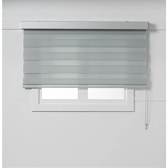 Estor noche y día Luxury - An x Al: 120 x 250 cm, Gris - Persianas grises frente a una ventana, filtrando la luz y brindando privacidad. Las persianas enrollables modernas ofrecen un elegante tratamiento de ventana.