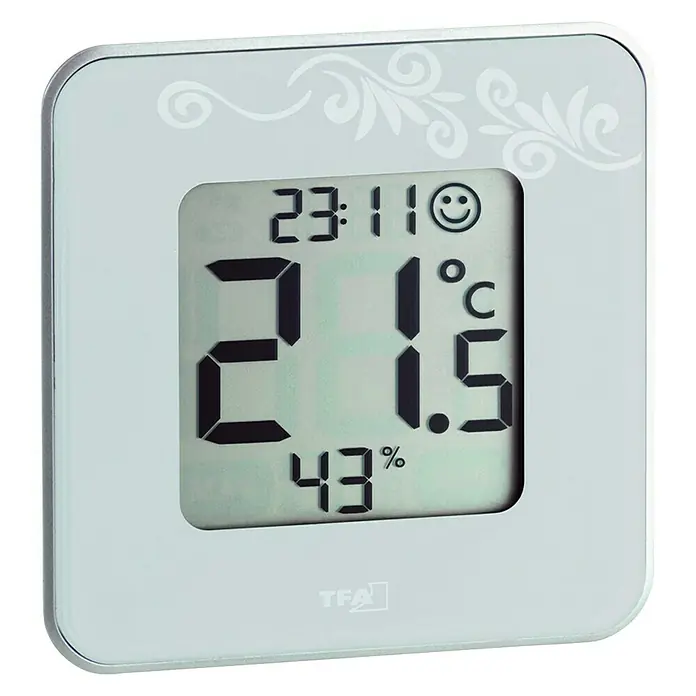 Termo-higrómetro Reloj plata - Indicación de temperatura interior - Una estación meteorológica digital TFA Dostmann que muestra la hora, la temperatura y la humedad en una elegante carcasa blanca.