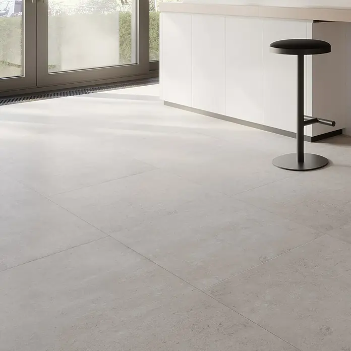 My Home Feinsteinzeugfliese - 60 x 120 cm, Grau, Matt - Minimalistisches Küchendesign mit hellgrauen Bodenfliesen und einem eleganten Barhocker.