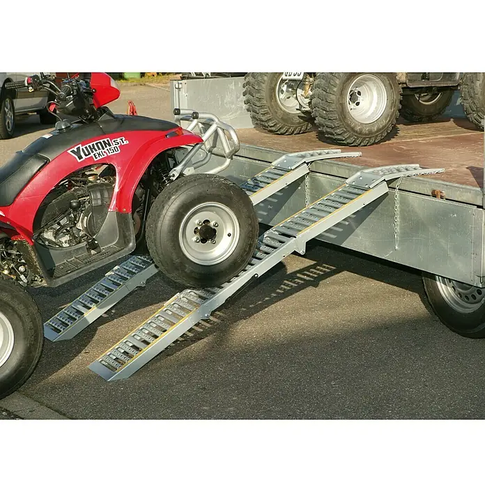 UniTEC Auffahrrampen-Set - Klappbar, 2 Stk., 200 x 23 cm - Bild von zwei silbernen Verladerampen mit gelben Akzenten, die an einem Anhänger befestigt sind, mit einem roten ATV teilweise darauf.
