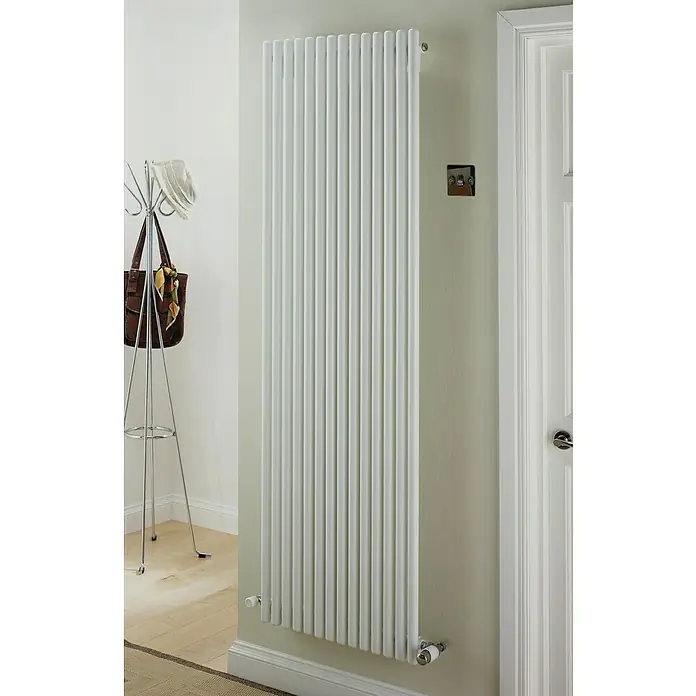 Ximax Raumheizkörper Kamino - B x H: 590 x 1.800 mm, Wärmeleistung bei Vorlauftemperatur von 75 °C (D: 50): 1.425 W - Ein moderner, weißer Heizkörper mit vertikalen Rippen hängt an einer hellgrünen Wand in einem Flur. Der Heizkörper sorgt für Wärme und Eleganz.