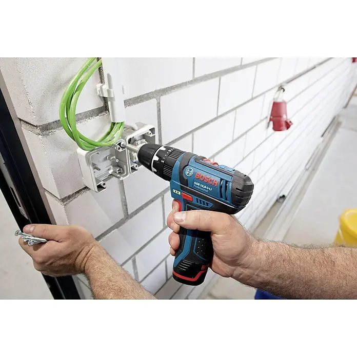 Bosch Professional Akku-Schlagbohrschrauber GSB 12V-15 - 12 V, Ohne Akku, 30 Nm, Ohne Akku, in Karton - Nahaufnahme eines Bosch GSB 10,8-2-LI Akku-Bohrschraubers beim Festziehen einer Schraube in einer elektrischen Anschlussdose.