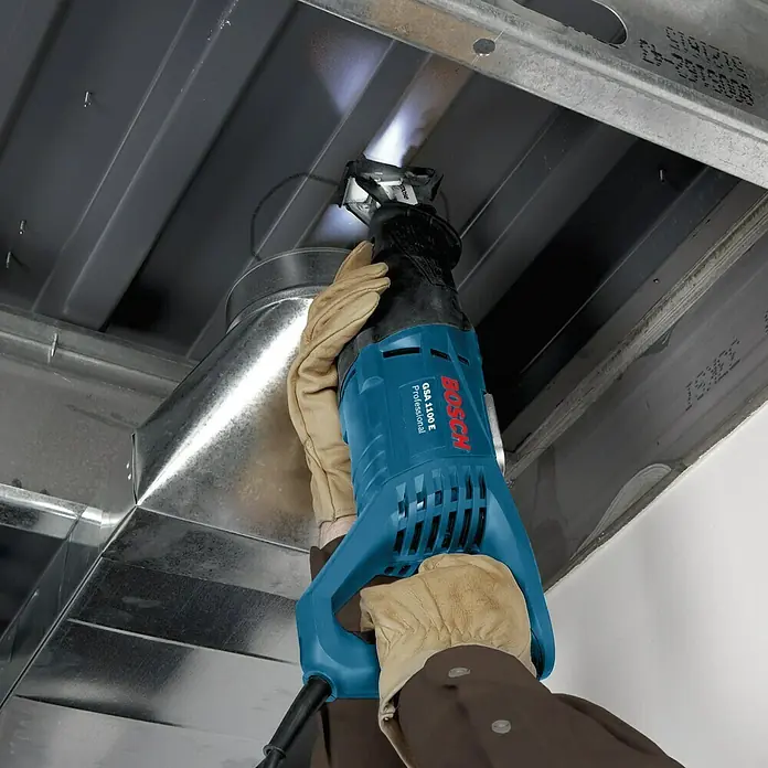 Bosch Professional Säbelsäge GSA 1100 E - 1.100 W, Hublänge: 28 mm - Nahaufnahme einer Bosch GSA 1100 E Säbelsäge beim Schneiden von Metall, bedient von einer Person mit Schutzhandschuhen.