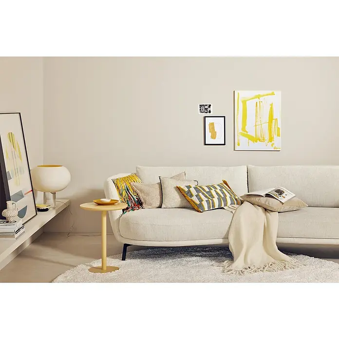SCHÖNER WOHNEN-Farbe Wandfarbe Trendfarbe Jubiläumsedition - Ibiza, Matt, 2,5 l, Konservierungsmittelfrei - Wohnzimmer mit stilvollem Sofa, Kissen und Dekorationen in harmonischen Farben. Das helle Sofa lädt zum Entspannen ein.