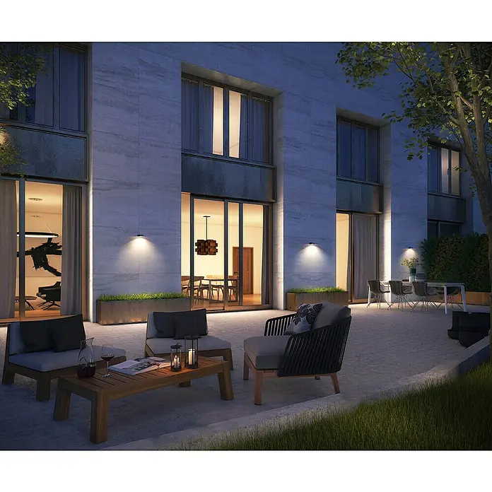 Garza Aplique solar para exterior Onix - L x An x Al: 12,1 x 15,2 x 5 cm, Negro, 1.000 lm - Patio exterior con asientos elegantes, iluminación cálida y arquitectura moderna creando un ambiente acogedor.
