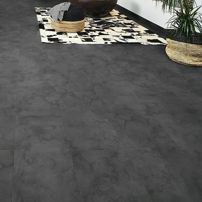 LOGOCLIC Ceramico Laminat - Dark Slate, Fliese, 638 x 330 x 8 mm - Detailaufnahme eines Bodens mit grauen Fliesen im Innenbereich, ergänzt durch dekorative Körbe und ein gemustertes Tuch.