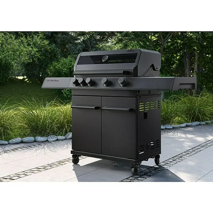 Kingstone KMS Gasgrill Cliff 4500 Beast Black Edition - Grillfläche (B x T): 72 x 45 cm, 14 kW, Anzahl Brenner: 4 Stk. - Schwarzer Grill mit Seitentisch und vier Reglern für die Temperaturregelung. Der Grill steht auf einer Terrasse im Freien.