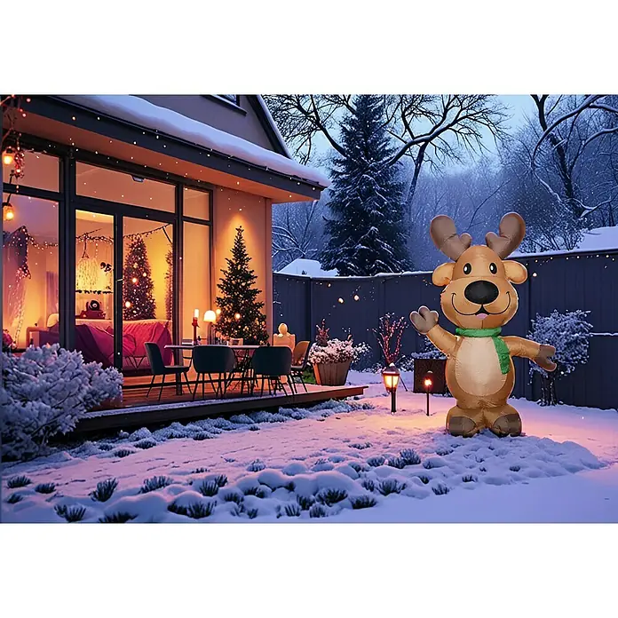 Figura LED navideña Reno con lazo - 153 x 74 x 244 cm, Multicolor, Funcionamiento en red, LED - Una escena festiva con un reno inflable en la nieve, frente a una casa adornada con luces y un árbol de Navidad.