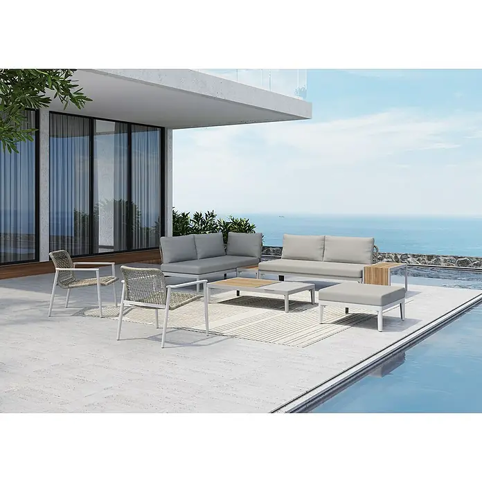 Sunfun Loungemöbel-Set Solo Rope - 9 -tlg., Aluminium/Polyrattan/Olefin, Light-Greige - Eine stilvolle Gartengarnitur mit grauem Sofa, Sesseln und Couchtisch auf einer Terrasse mit Meerblick.