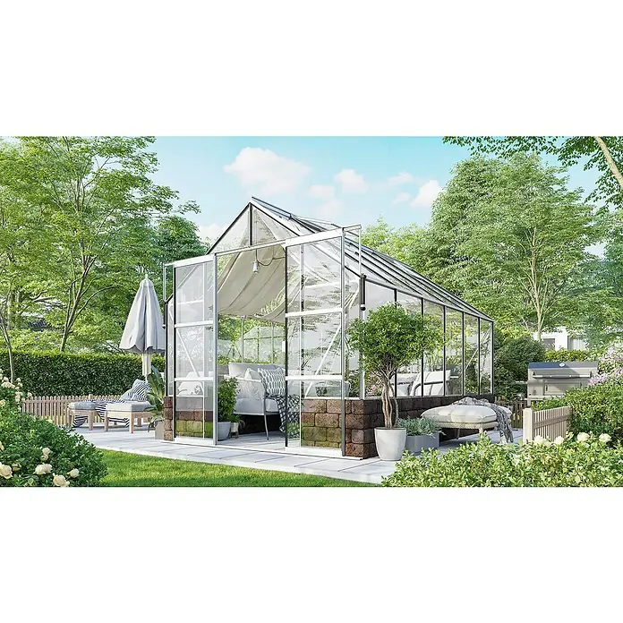 Vitavia Gewächshaus Cassandra 9900 Plus - Außenmaß inkl. Dachüberstand (B x T): 257 x 385 cm, 3 mm, Aluminium/ Herbstlaub - Ein geräumiges Gewächshaus im Garten, ausgestattet mit Sitzecke und Pflanzen, ideal für entspannte Stunden und Gartenarbeit.