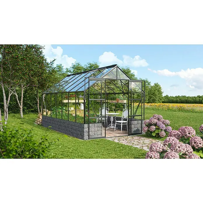 Vitavia Gewächshaus Cassandra 11500 Plus - Außenmaß inkl. Dachüberstand (B x T): 257 x 448 cm, 3 mm, Schwarz - Ein wunderschönes Gewächshaus mit robustem Rahmen und klaren Glasflächen, umgeben von grüner Natur und blühenden Pflanzen.