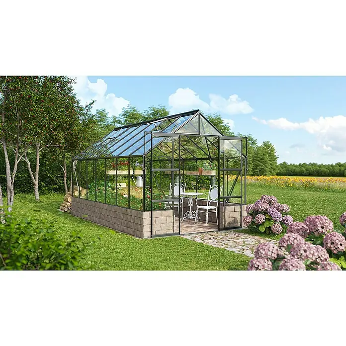 Vitavia Gewächshaus Cassandra 9900 Plus - Außenmaß inkl. Dachüberstand (B x T): 257 x 385 cm, 3 mm, Schwarz - Ein Gewächshaus mit Glaswänden und einem stabilen Rahmen inmitten eines blühenden Gartens, ideal für Pflanzenzucht und entspannte Stunden im Grünen.