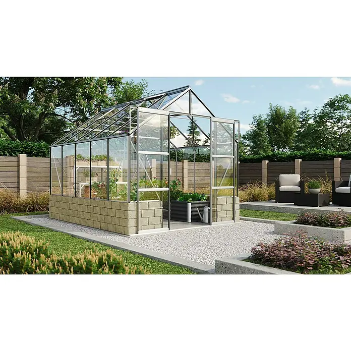 Vitavia Gewächshaus Cassandra 8300 - Außenmaß inkl. Dachüberstand (B x T): 257 x 323 cm, 3 mm, Aluminium - Dieses Bild zeigt ein Gewächshaus mit solidem Steinunterbau, das in einem gepflegten Garten steht. Das Gewächshaus ist mit Pflanzen bestückt.
